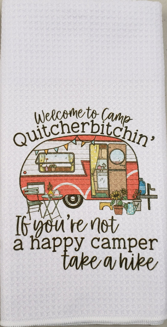 A white waffle-weave kitchen towel featuring a retro red and orange camper illustration with the text 'Welcome to Camp Quitcherbitchin'' and 'If you're not a happy camper take a hike'.